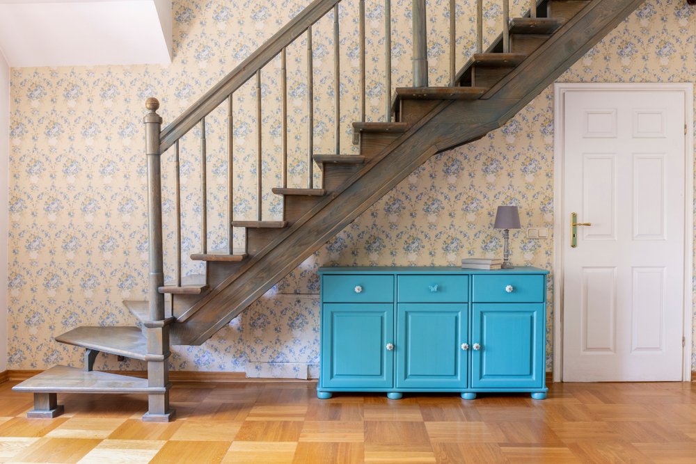 Een afbeelding van een prachtig geschilderd trappenhuis met een neutrale kleur, decoratieve lijsten en een elegante trapleuning, illustratief voor de tips en suggesties voor het schilderen van een trappenhuis voor een verbluffende transformatie.